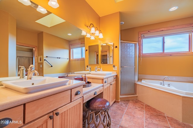 bathroom with tile floors, a skylight, dual sinks, vanity with extensive cabinet space, and plus walk in shower