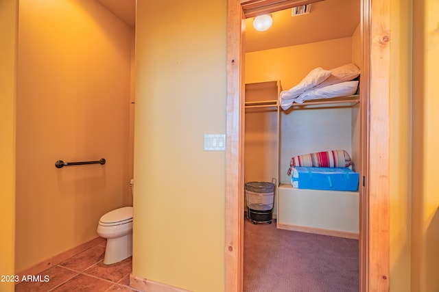 bathroom featuring tile flooring and toilet