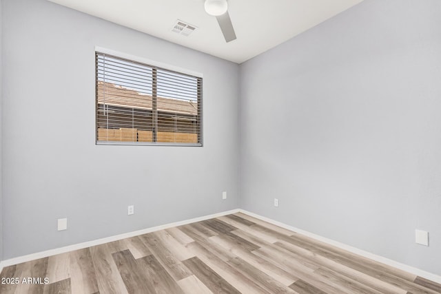 unfurnished room featuring a ceiling fan, baseboards, visible vents, and wood finished floors
