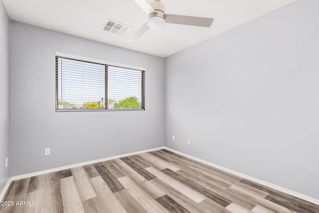 unfurnished room featuring a ceiling fan, baseboards, visible vents, and wood finished floors