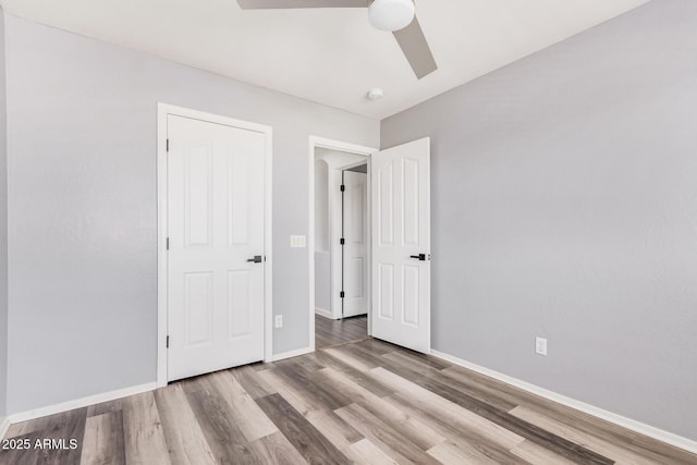 unfurnished bedroom featuring baseboards, ceiling fan, and wood finished floors