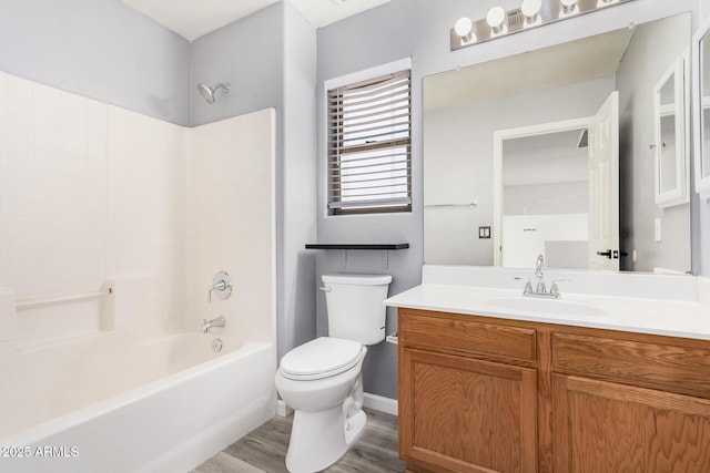 full bath featuring vanity, wood finished floors, toilet, baseboards, and shower / tub combination