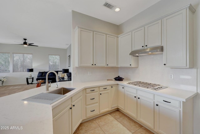 kitchen with visible vents, light countertops, under cabinet range hood, stainless steel gas cooktop, and light tile patterned flooring