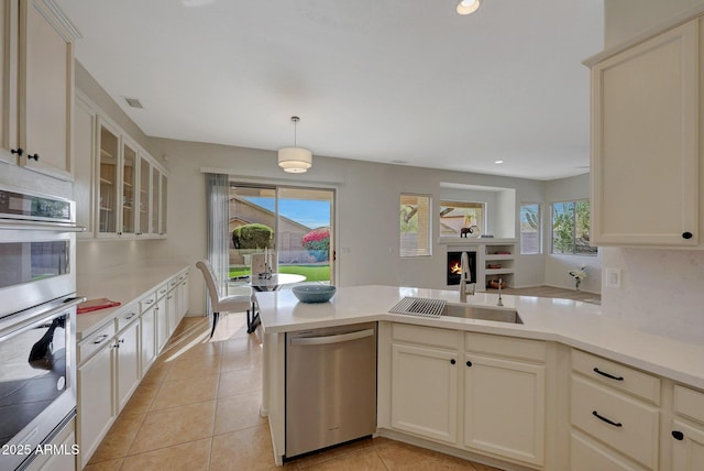 kitchen featuring glass insert cabinets, stainless steel appliances, and light countertops