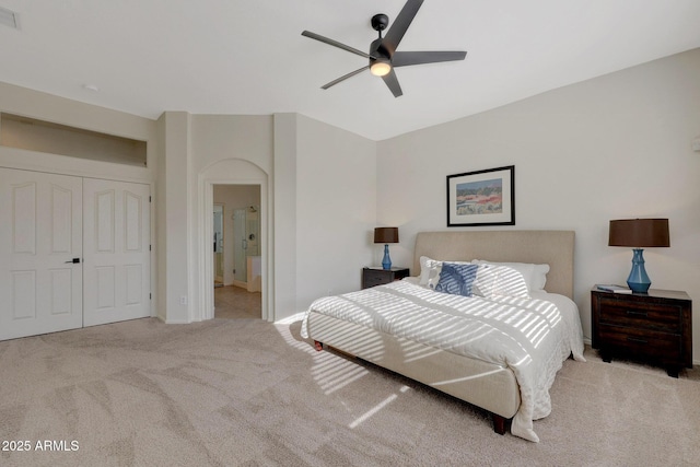 bedroom featuring light carpet, visible vents, a closet, and ensuite bathroom