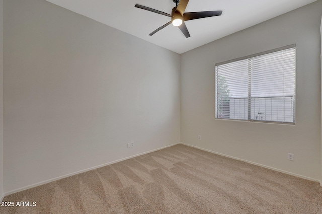 spare room featuring light carpet, ceiling fan, and baseboards