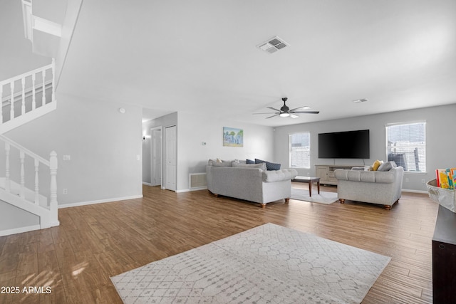 living area with a wealth of natural light, visible vents, and stairway