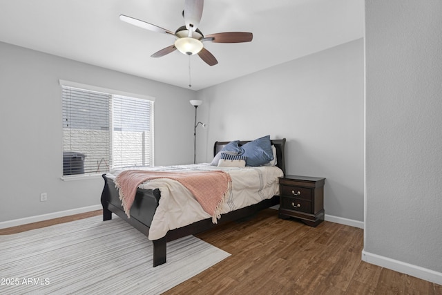 bedroom with ceiling fan, baseboards, and wood finished floors