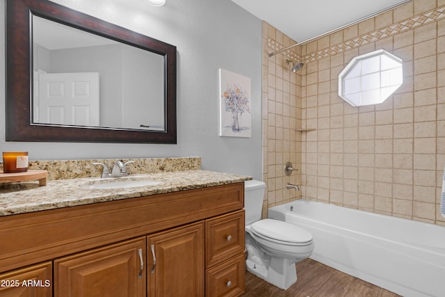 full bathroom featuring toilet, vanity, wood finished floors, and bathing tub / shower combination