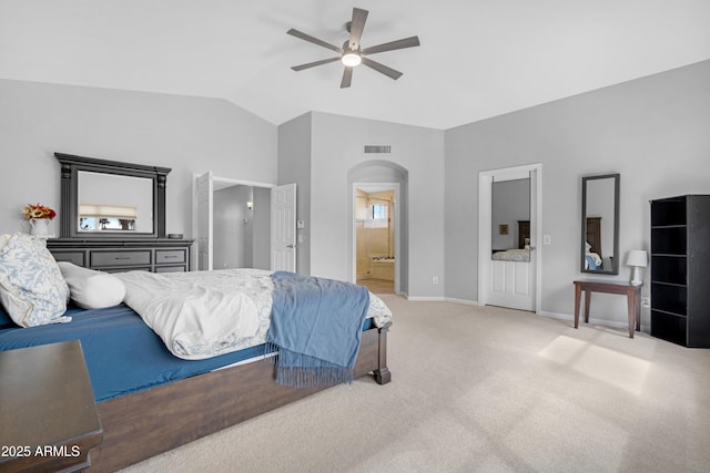 bedroom with lofted ceiling, arched walkways, ensuite bathroom, carpet floors, and visible vents