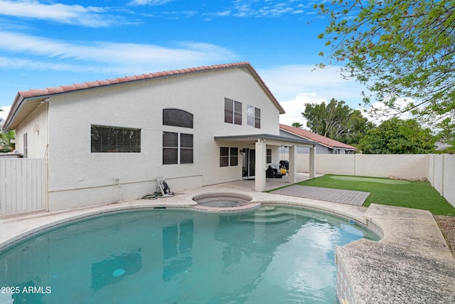 view of swimming pool with a pool with connected hot tub, a patio area, a fenced backyard, and a lawn