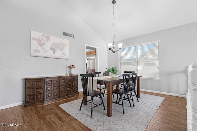 dining room with visible vents, a notable chandelier, baseboards, and wood finished floors