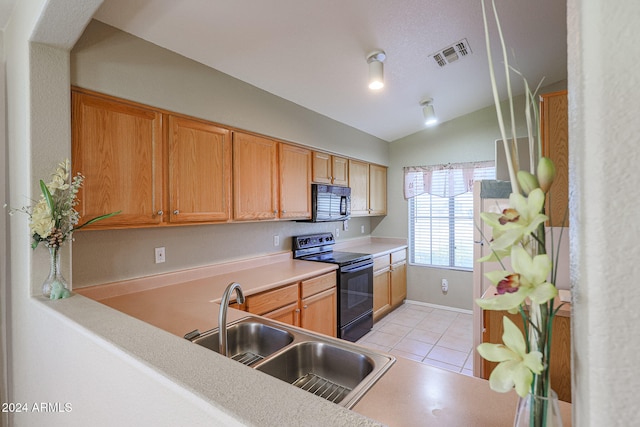 kitchen featuring light tile patterned flooring, sink, black appliances, and lofted ceiling