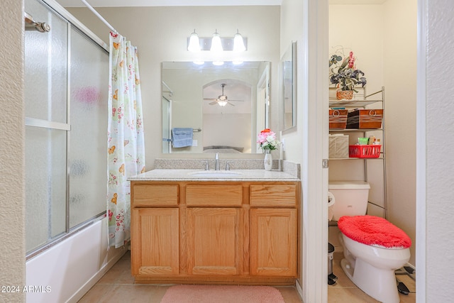 full bathroom featuring ceiling fan, shower / bath combination with glass door, vanity, tile patterned floors, and toilet