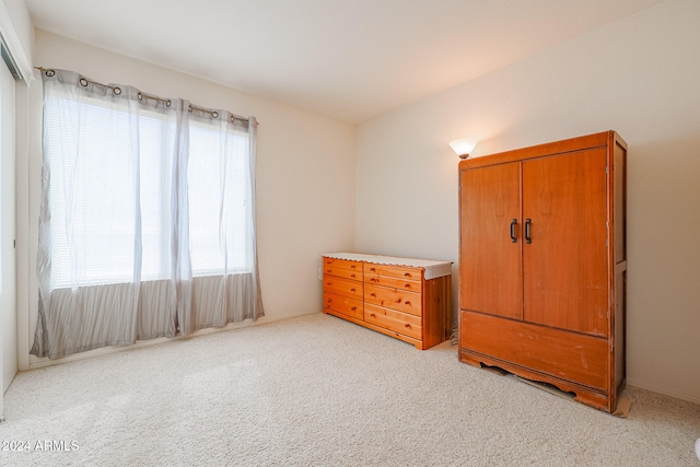 unfurnished bedroom featuring multiple windows and light carpet