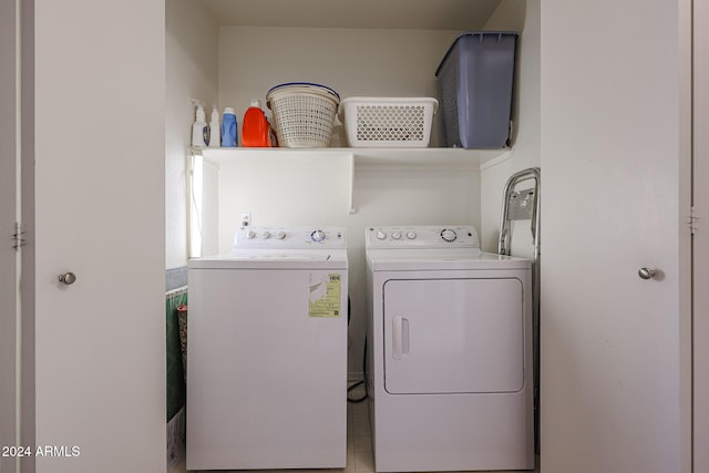 clothes washing area with light tile patterned flooring and washer and dryer