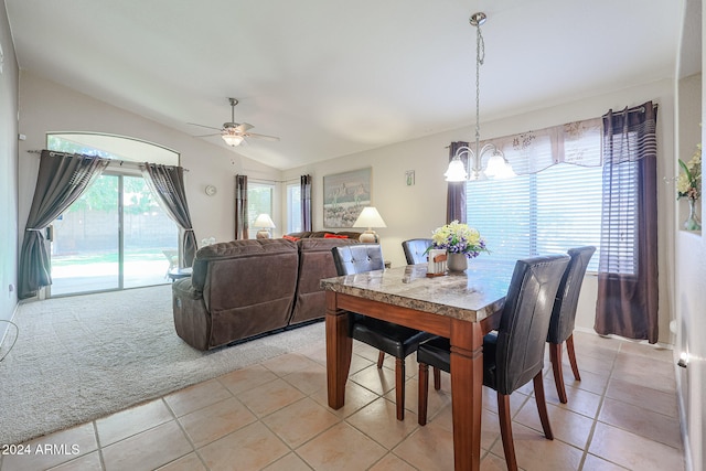 dining area featuring vaulted ceiling, light tile patterned floors, and ceiling fan with notable chandelier