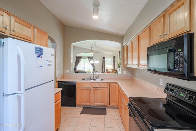 kitchen with black appliances, light tile patterned flooring, a textured ceiling, sink, and vaulted ceiling