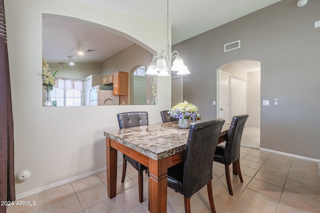 dining room featuring a chandelier and light tile patterned flooring