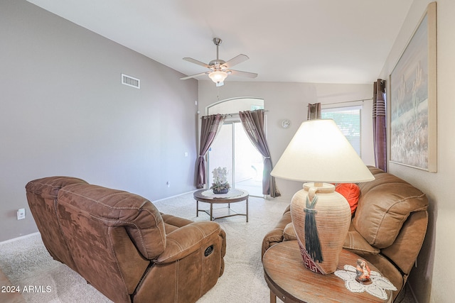 living room with vaulted ceiling, light carpet, ceiling fan, and plenty of natural light