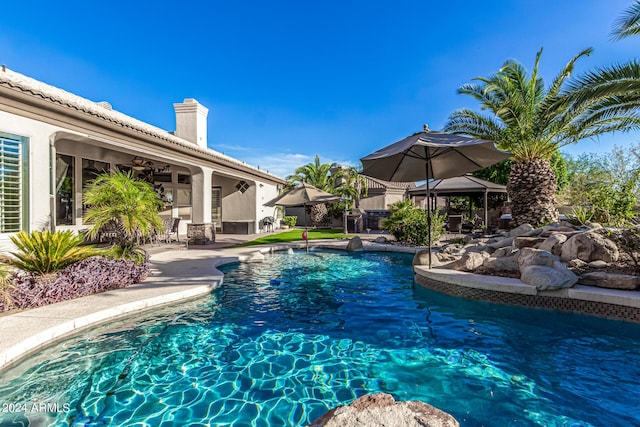 outdoor pool featuring a patio and a ceiling fan