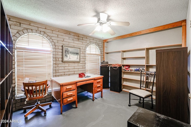 office area featuring a textured ceiling, ceiling fan, and concrete flooring