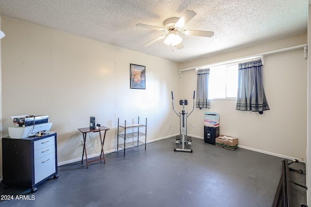 exercise room with a textured ceiling and ceiling fan