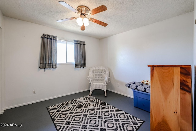 living area featuring a textured ceiling and ceiling fan