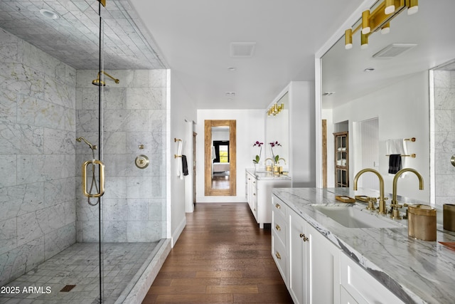 bathroom featuring wood-type flooring, a shower with shower door, and vanity