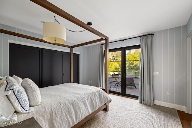 bedroom with access to exterior, hardwood / wood-style flooring, and french doors