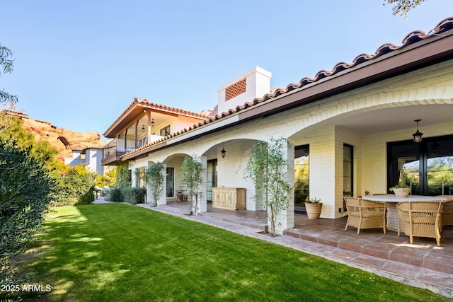 rear view of house featuring a yard and a patio area