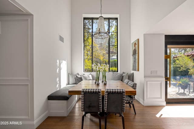 dining space featuring wood-type flooring, a notable chandelier, and breakfast area