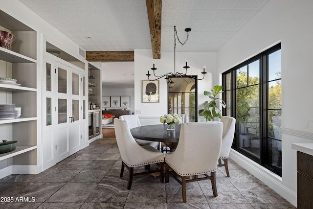 dining area featuring a notable chandelier, beam ceiling, and built in shelves