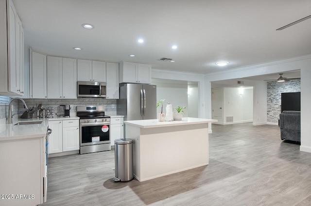 4202 W Purdue Ave, Phoenix, AZ 85051 - kitchen with appliances with stainless steel finishes, a sink, open floor plan, a center island, and light countertops