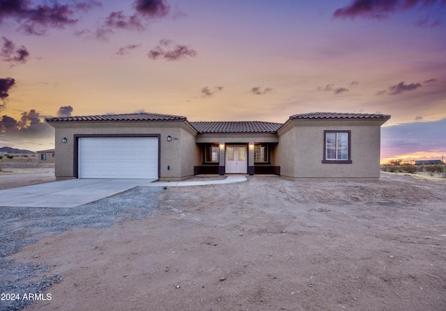 view of front of house with an attached garage, concrete driveway, and stucco siding