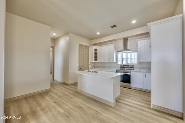 kitchen with wall chimney range hood, light countertops, white cabinetry, stainless steel electric stove, and light wood finished floors