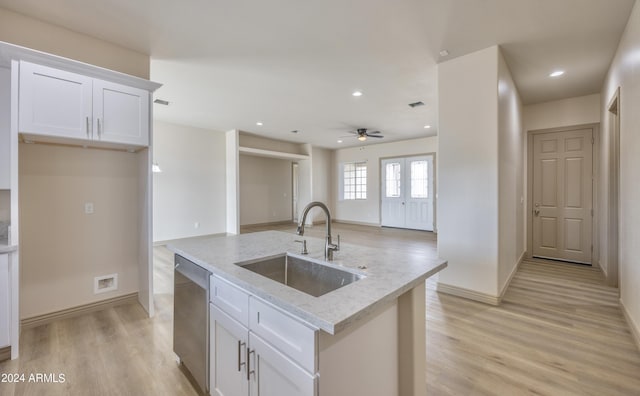 kitchen featuring light stone countertops, a sink, dishwasher, white cabinetry, and light wood-type flooring