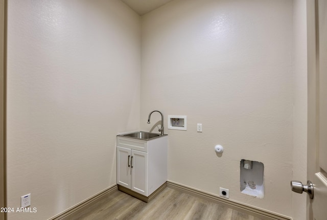 laundry area with light wood-style floors, baseboards, hookup for a washing machine, a sink, and hookup for an electric dryer