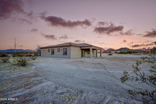 view of front of house featuring an attached garage, a mountain view, and stucco siding