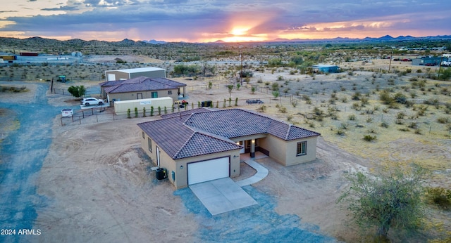aerial view at dusk with view of desert, a mountain view, and a rural view