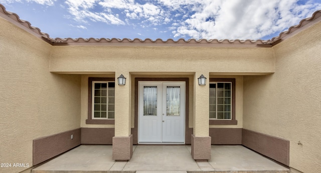 doorway to property featuring french doors and stucco siding