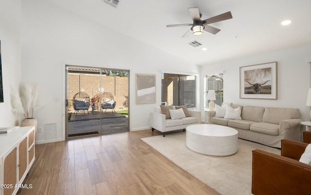 living room featuring ceiling fan, high vaulted ceiling, and light wood-type flooring