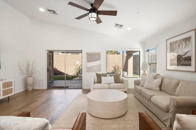 living room featuring hardwood / wood-style flooring, lofted ceiling, and ceiling fan