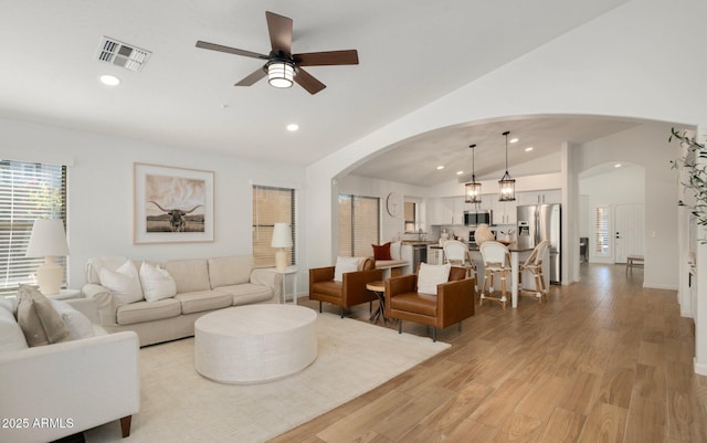 living room featuring ceiling fan, lofted ceiling, and light wood-type flooring