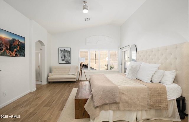 bedroom with wood-type flooring and high vaulted ceiling