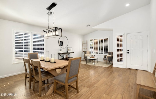 dining space with lofted ceiling and light hardwood / wood-style flooring