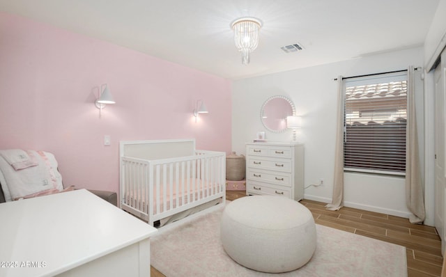 bedroom featuring an inviting chandelier and a crib