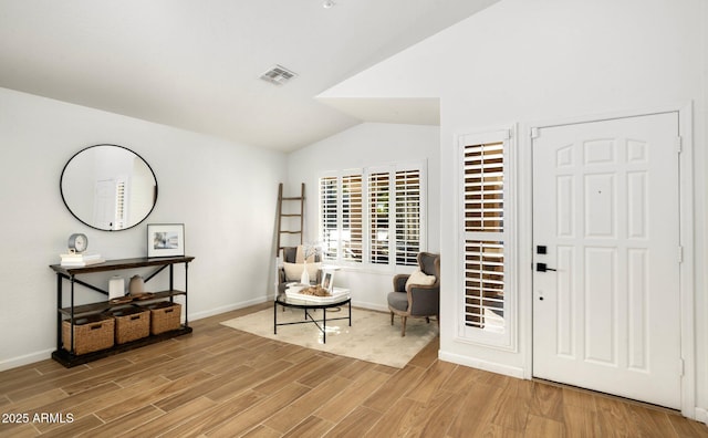 interior space with hardwood / wood-style flooring and vaulted ceiling