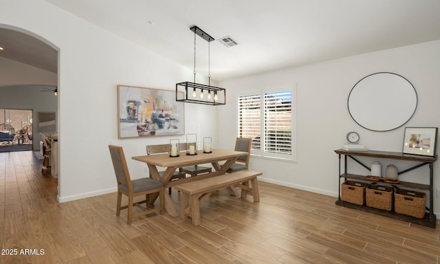 dining space with vaulted ceiling, hardwood / wood-style floors, and ceiling fan