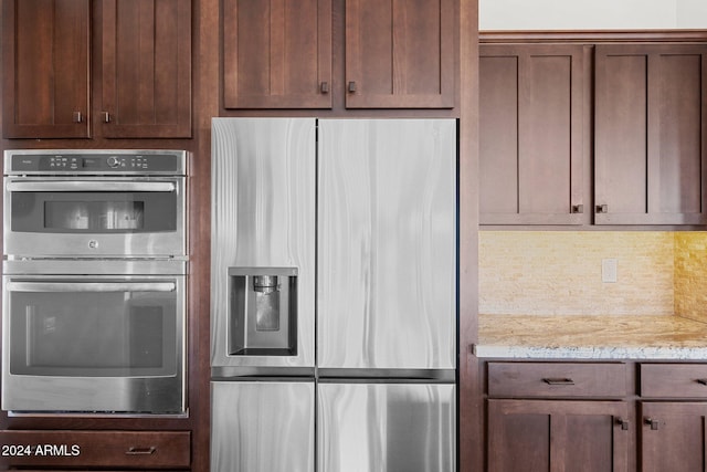 kitchen with decorative backsplash, appliances with stainless steel finishes, and light stone counters